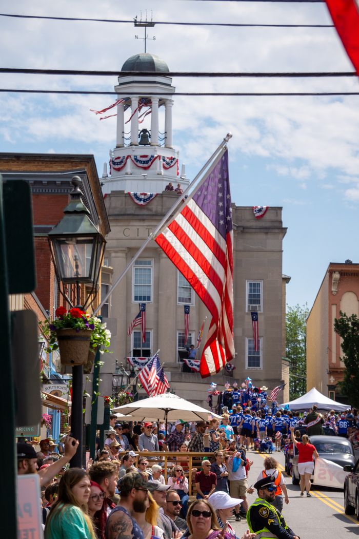 Crafting Captivating Headlines: Your awesome post title goes here A lively parade event with crowds and American flags in a small town setting.