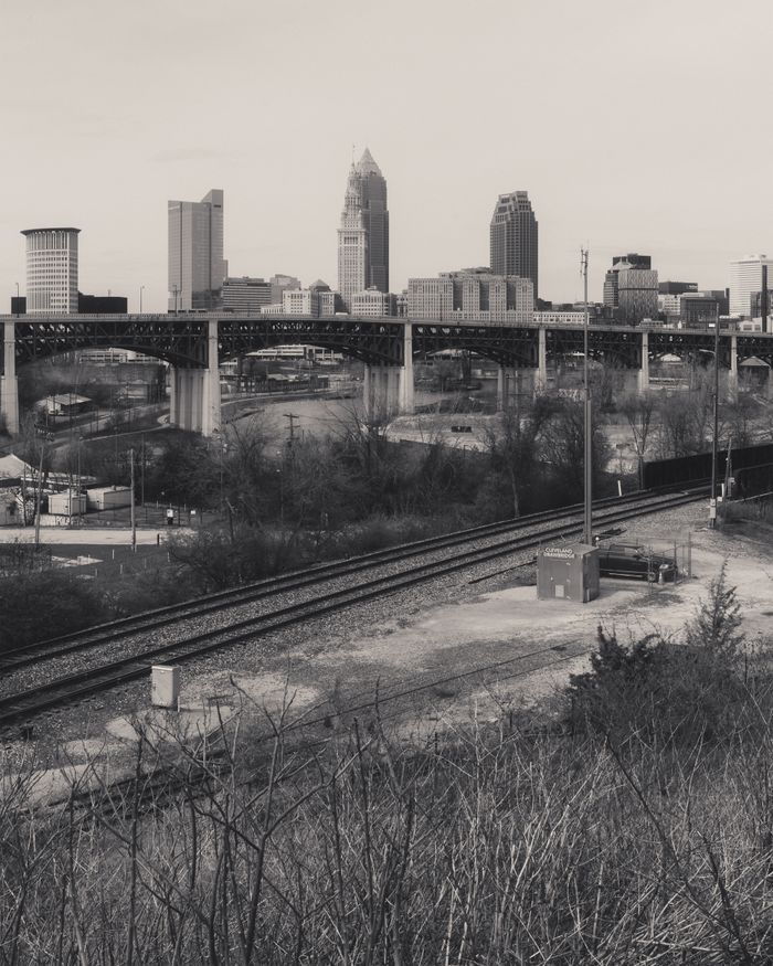 Mastering the First Impression: Your intriguing post title goes here Monochrome view of Cleveland's skyline with urban railroads and overcast skies.